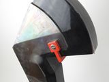 a close up of a black and red sculpture on a white surface
