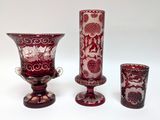 three vases and a glass on a white surface