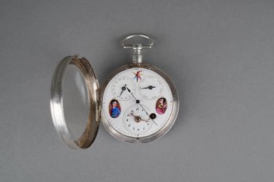 a silver pocket watch with a picture of people on it