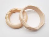 two wooden bangles sitting on a white surface