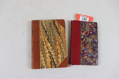 deux livres sont posés l'un à côté de l'autre sur une surface blanche