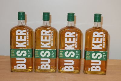 Quatre bouteilles de Busser sont alignées sur une table en bois
