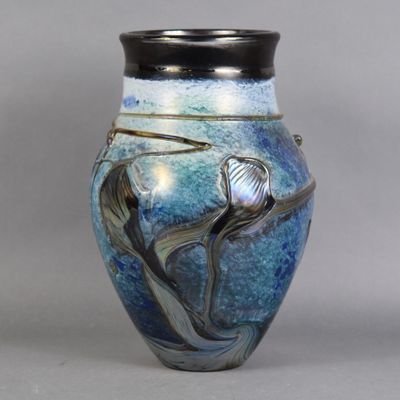 un vase bleu orné d'un oiseau, posé sur une table