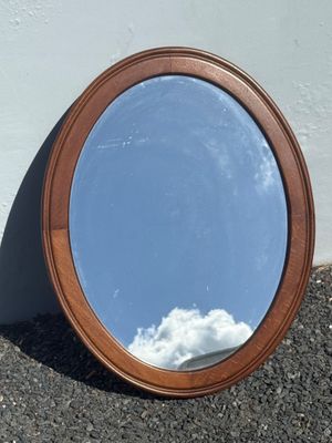 a mirror sitting on the ground with a sky in the background