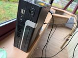 a computer sitting on top of a desk next to a window