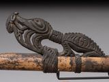 a close up of a wooden stick with a bird on it