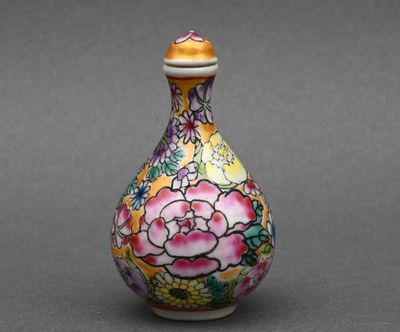 une image représentant un vase coloré orné de fleurs, posé sur une surface grise
