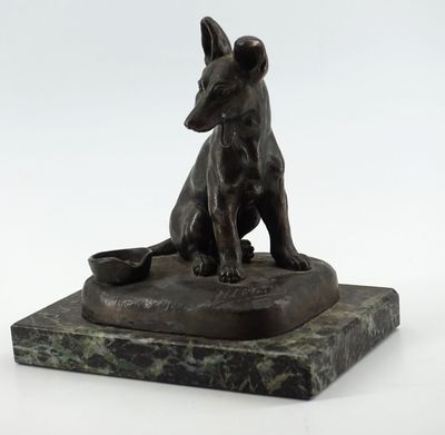 statue en bronze représentant un chien assis sur un socle en marbre