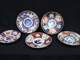 six plates with different designs on them sitting on a black surface