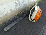 a chainsaw that is laying on the ground next to a wall