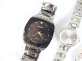 two watches sitting next to each other on a white surface