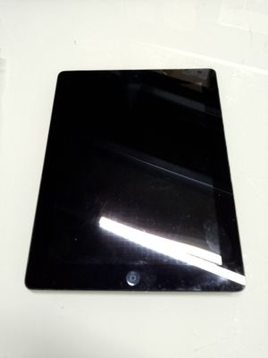 une tablette noire posée sur une table blanche