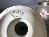 a white vase and a silver teapot on a table