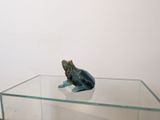 a glass table with a figurine of a frog on it
