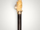 an old wooden walking stick with a carved head on it