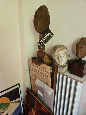 un radiateur dans un coin d'une pièce où sont accrochées des œuvres d'art