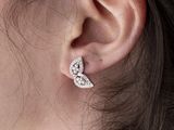 a close up of a woman ' s ear wearing a pair of earrings