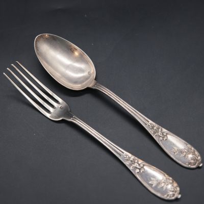 two spoons and a fork on a black surface