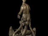 bronze figurine of a man on a boat with a dog