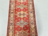 a long red rug on a white floor in a room