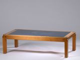 une table en bois avec un plateau en verre, posée sur un plan de travail blanc