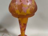 a glass vase with a pink and yellow design on it