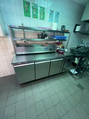 une grande cuisine équipée de plans de travail et d'armoires en acier inoxydable
