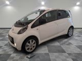 une petite voiture blanche garée dans une pièce