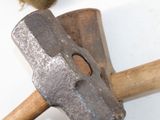 a hammer with a wooden handle on a white surface