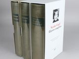three books sitting on top of a white box on a table