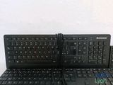 two black keyboards sitting next to each other on a table