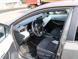 the interior of a car with the door open and the driver ' s seat down