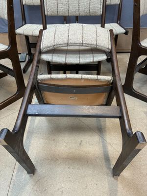 three wooden chairs with upholstered seats in a room with blue walls