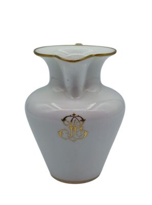 a white vase with a gold decoration on it
