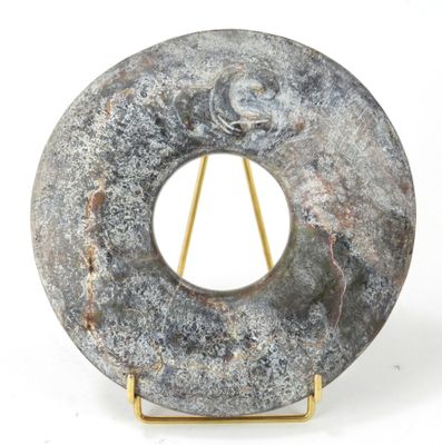 une sculpture en pierre représentant un objet circulaire posé sur un socle