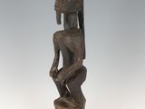 une image représentant une statue en bois d'un homme portant un casque sur la tête