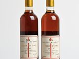 deux bouteilles de vin posées sur une table l'une à côté de l'autre