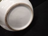 a close up of a white vase with a gold trim