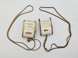 two cell phones sitting on top of a white table next to each other
