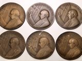 six médaillons en bronze représentant des hommes aux visages différents