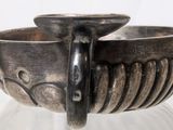 a silver bracelet that is on display on a table