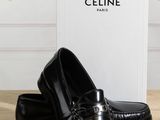 a pair of black shoes sitting on top of a wooden table