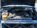 a blue car with its hood open and a gas can in the trunk
