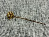un gros plan d'une broche en or ornée d'une fleur