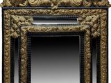an ornately carved mirror with a gold frame on a white background