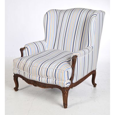 an upholstered striped chair with wood legs and arms