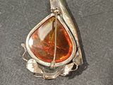 sterling silver and amber broochle on a black surface