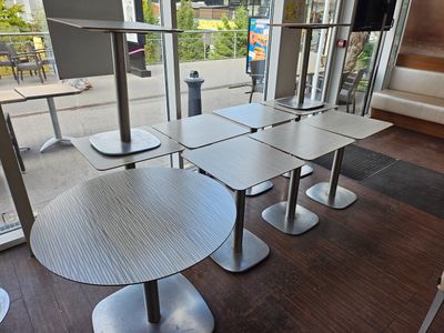 four tables and four chairs in a room with a large window