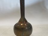 an antique bronze vase on a white surface with a white background