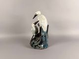 a white bird sitting on top of a rock in the water